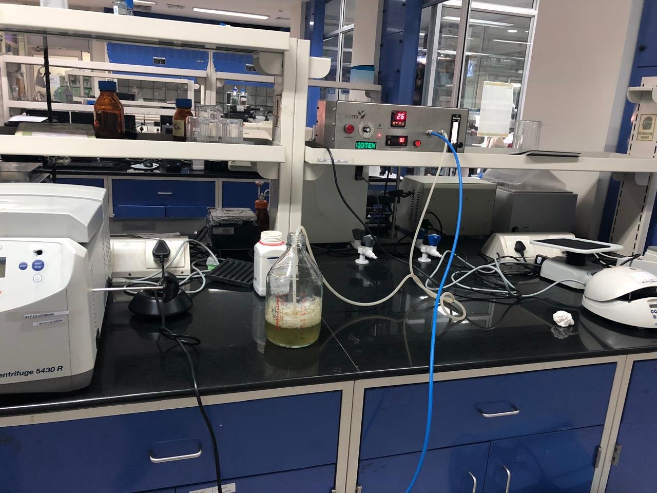 Laboratory bench with a stirring bottle of liquid and various scientific equipment