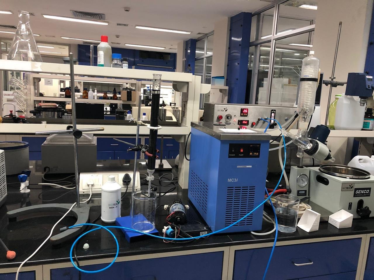 Laboratory bench with a blue MC3i chilling unit, a chromatography column, and other scientific apparatus